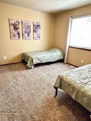 A bedroom with two single beds, a carpeted floor, and three abstract paintings on the wall. - Raptor Retreat, 3BR/3Bath North Spokane Home Base (Spokane)