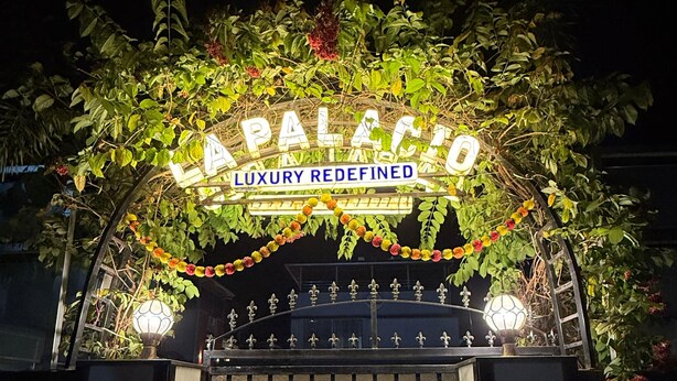 Una entrada protegida por una reja con un letrero que dice 'PALACE LUXURY REDEFINED'.