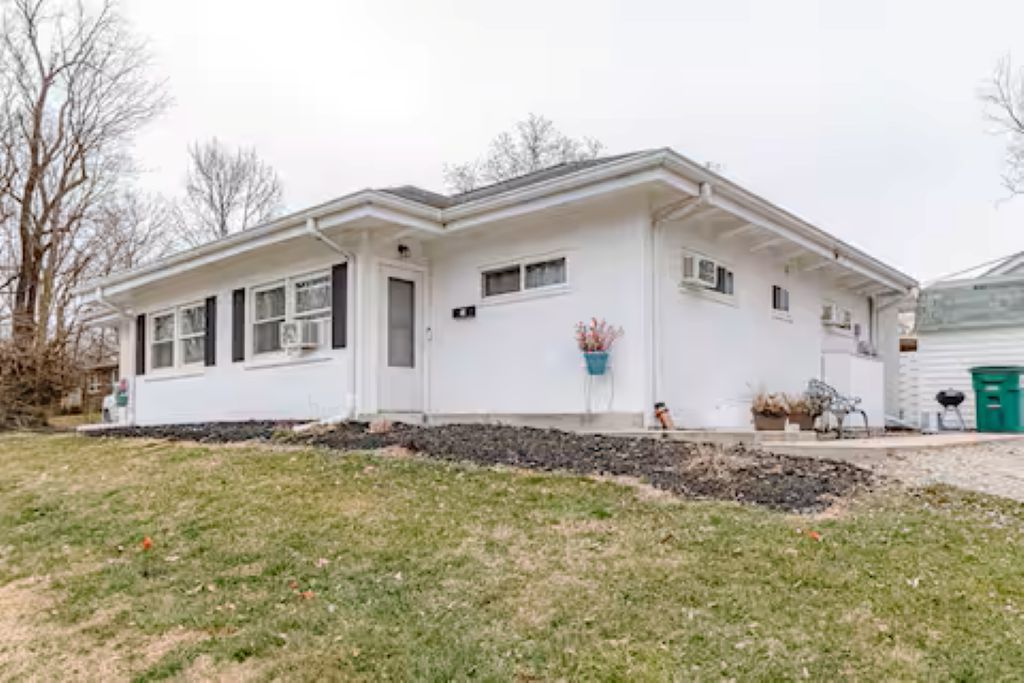 A single-story house with a front porch, a garage, and a small front yard.