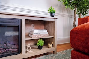 A wooden console table with books, a small plant, and a decorative item. - Stylish 2BR apt in beautiful Petersburg w/ parking, laundry, & outdoor space (Petersburg)