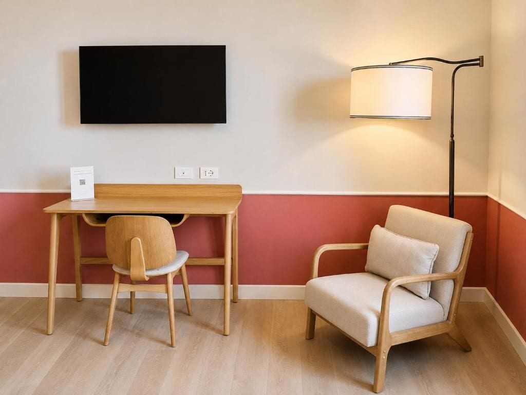 Ein Zimmer mit Schreibtisch, Stuhl und Stehlampe.
