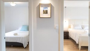 Ein Hotelzimmer mit einem Bett, einem Nachttisch und einem gerahmten Bild an der Wand.