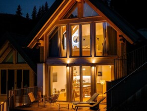 A modern two-story house with a balcony, large windows, and a well-lit interior. - Cabin in Niederwolz With Sauna (Oberwölz)