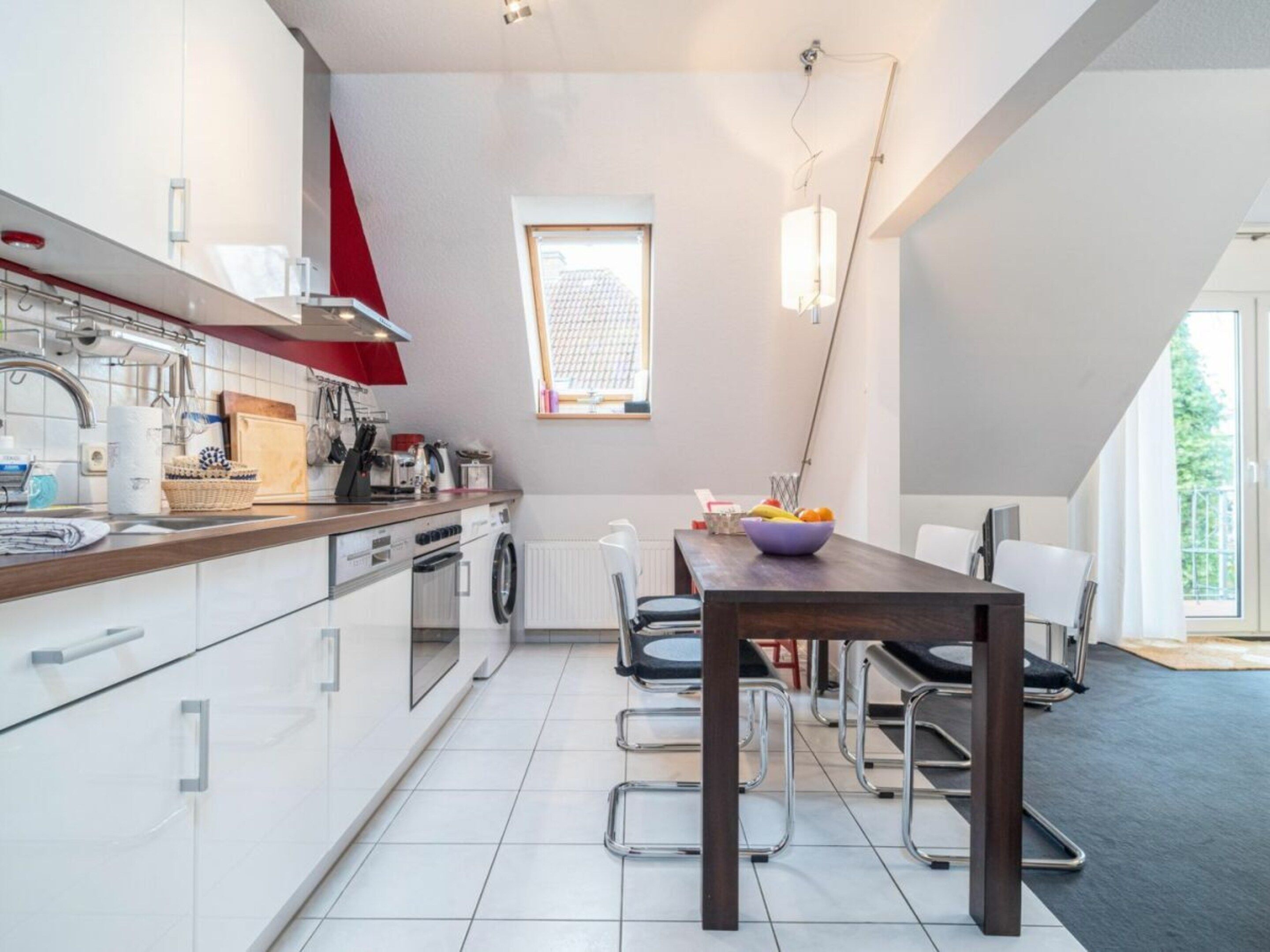 Une cuisine moderne avec un coin repas, une fenêtre et une vue sur l’extérieur.