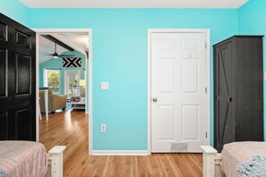 Une pièce avec un mur de couleur turquoise, une porte blanche et une armoire en bois foncé.