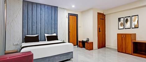 Une chambre à coucher moderne avec un lit, des tables de chevet, une armoire et un fauteuil rouge.