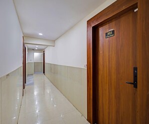 A hotel corridor with a wooden door labeled '305 U Turn Hotel' and a tiled floor. - Classic Hotel U Turn & Restaurant (Dr. Ambedkar Nagar)