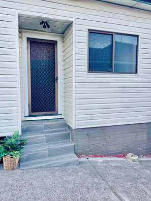 A house with a front door, a window, and a small porch.