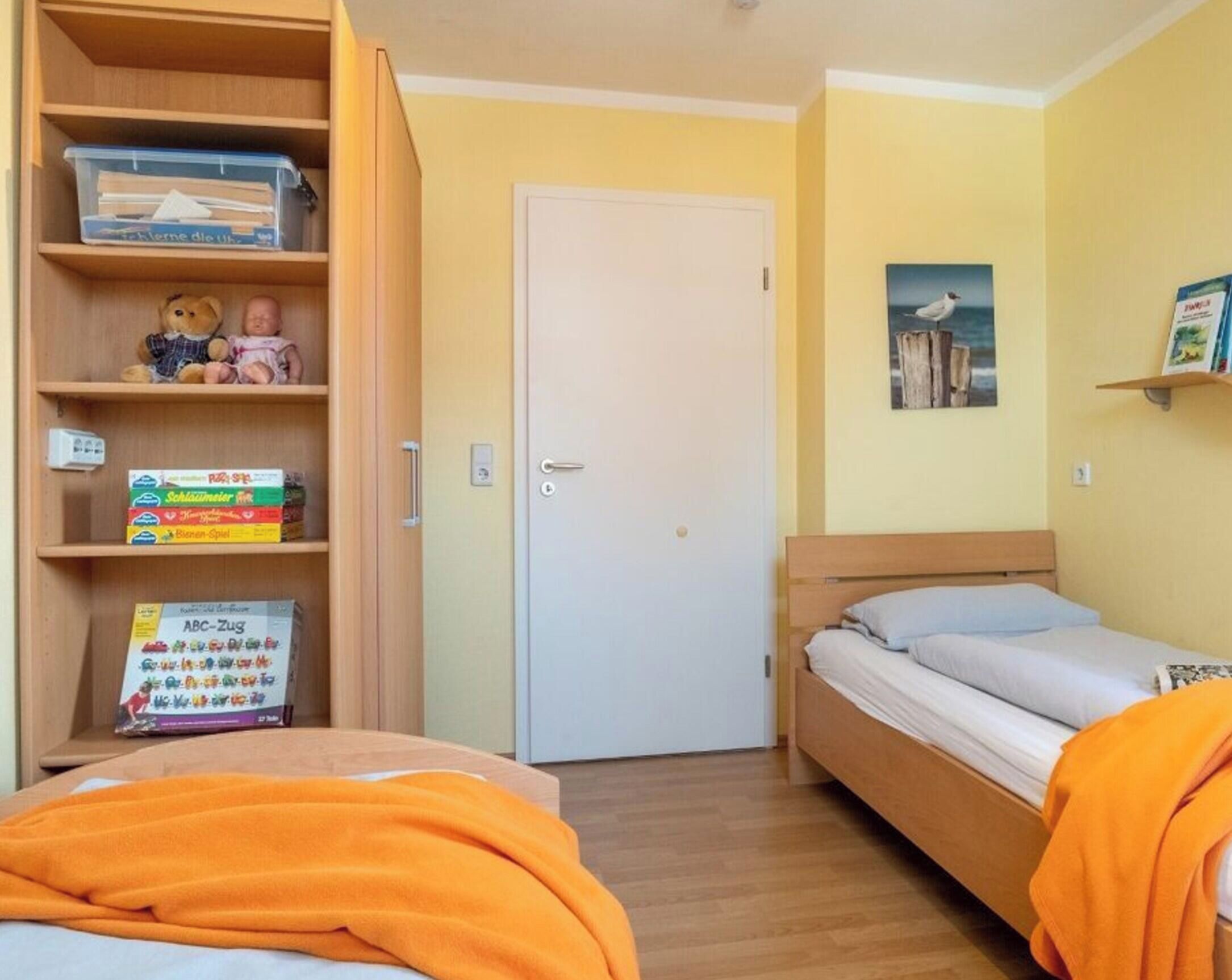 Ein Zimmer mit zwei Betten, einem Kleiderschrank und einer Tür.