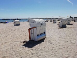 Fila de cabañas frente al mar, numeradas del 38 al 43, con vista despejada al mar y un muelle al fondo.