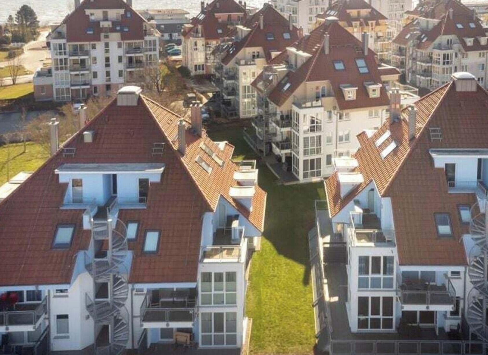A residential area with multiple houses featuring pitched roofs and balconies.