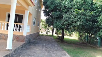 Un edificio con un camino empedrado de piedra que lleva a una entrada cubierta con columnas blancas.
