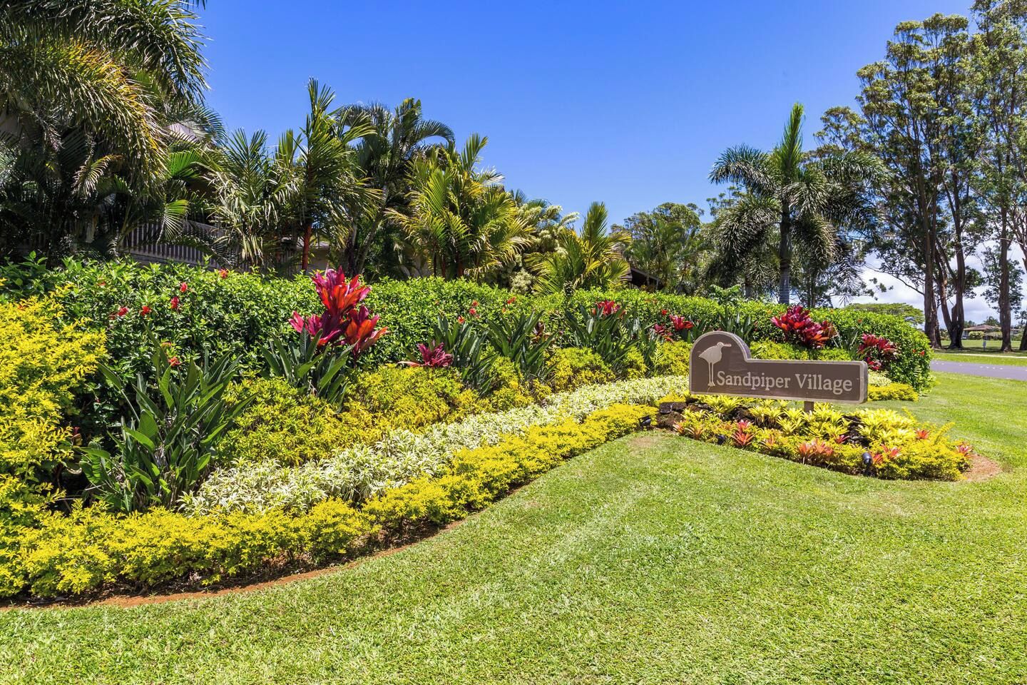 Un jardín ajardinado con un letrero que dice 'Sandpiper Village'.