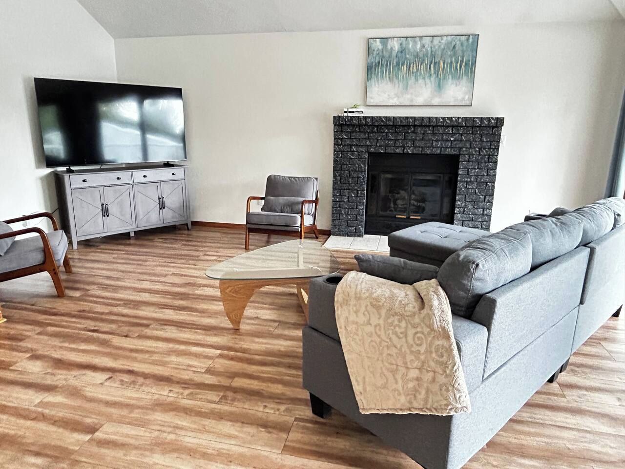 Una sala de estar moderna con chimenea, televisor y sofá.