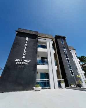 A modern apartment building with a sign indicating it is for rent. - Beautiful 3-bedroom apartment,3 Min walk to the Beach,Costambar Puerto Plata,DR (Puerto Plata)