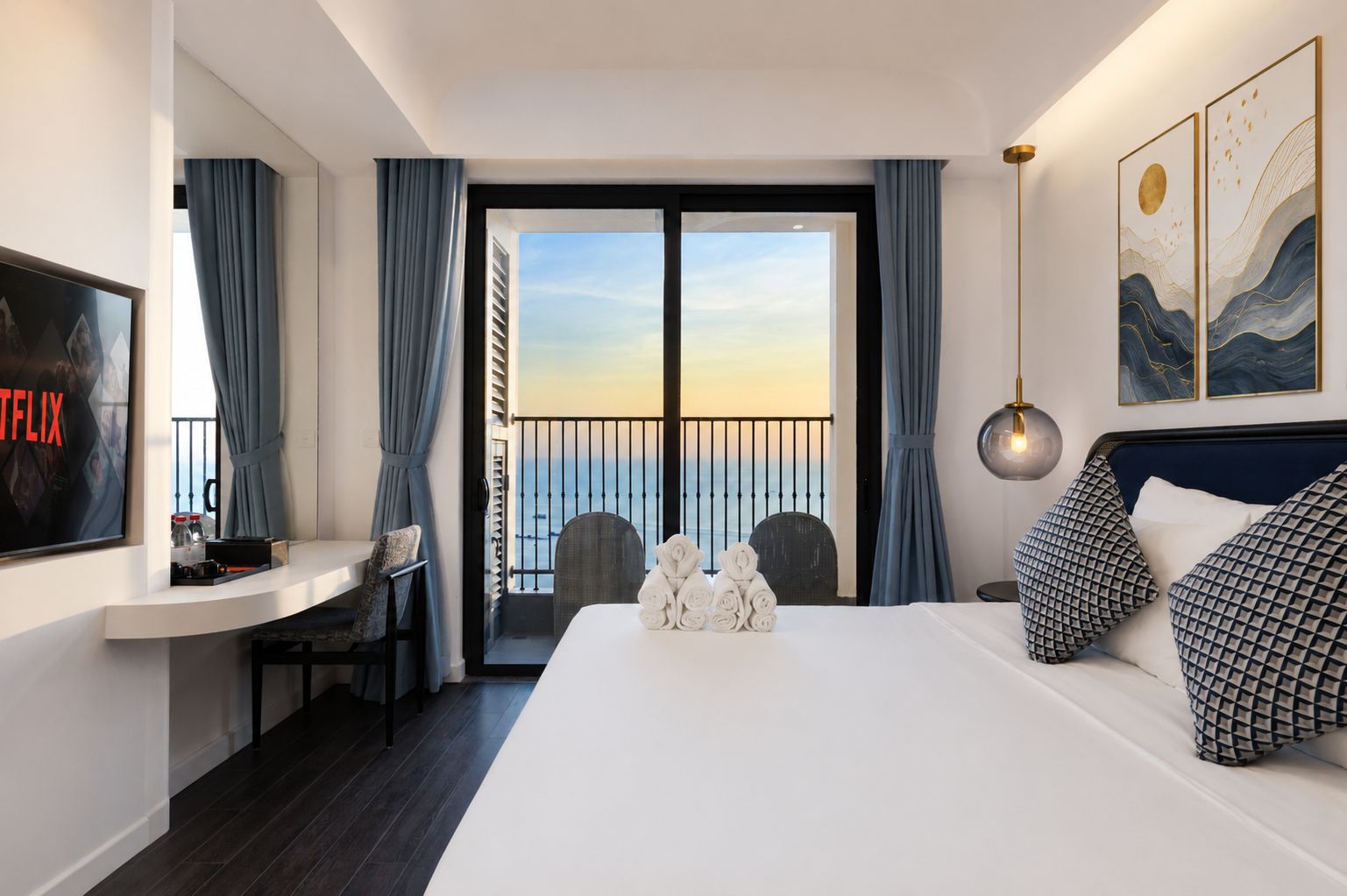 Une chambre d’hôtel avec un lit, un bureau, une télévision et un balcon offrant une vue.