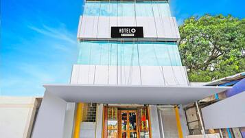 A hotel with a sign reading 'HOTELO & Company Serviced' and a modern facade with a glass entrance.