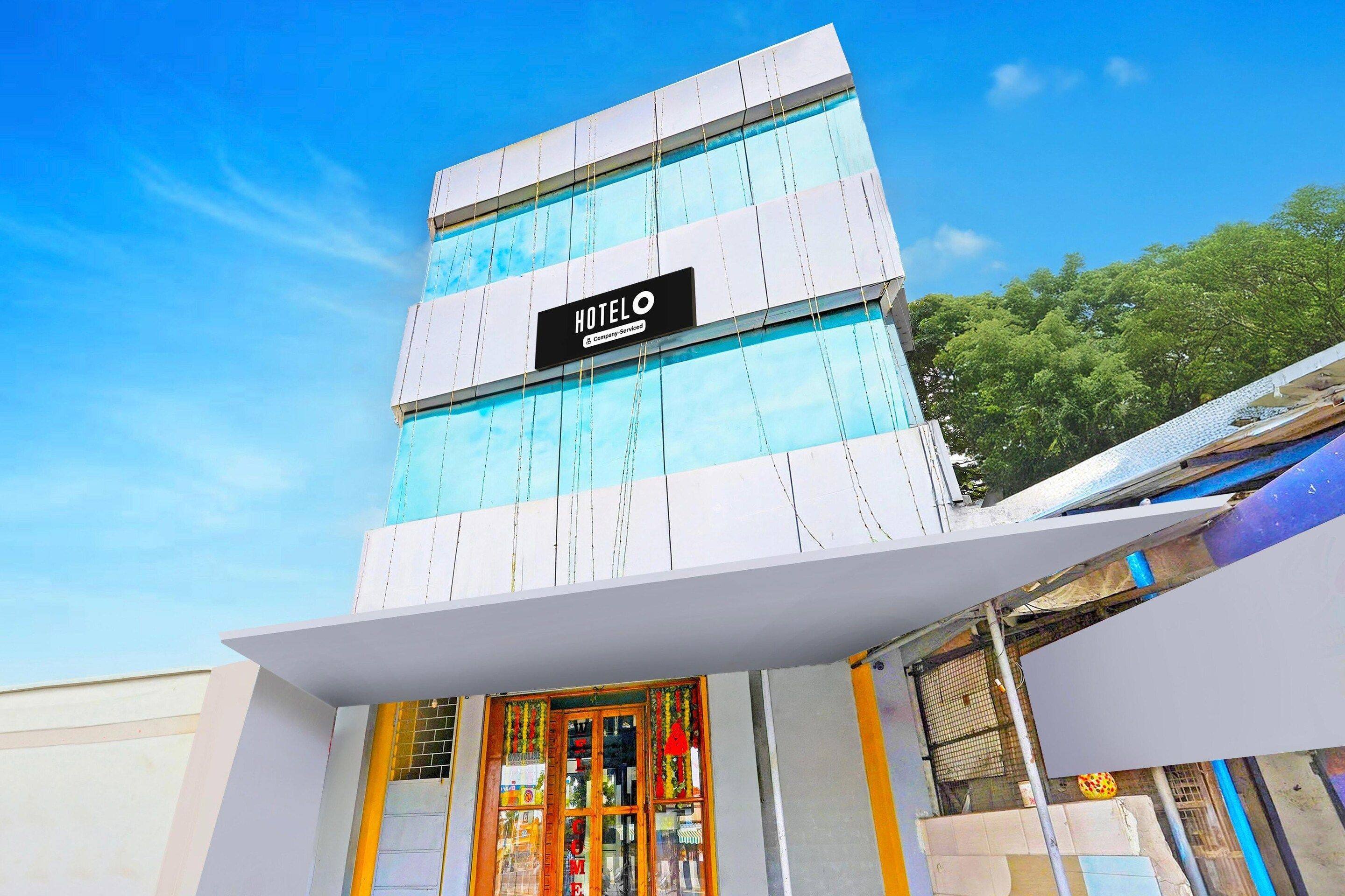 A hotel with a modern facade, a prominent sign, and a large entrance with a glass door.