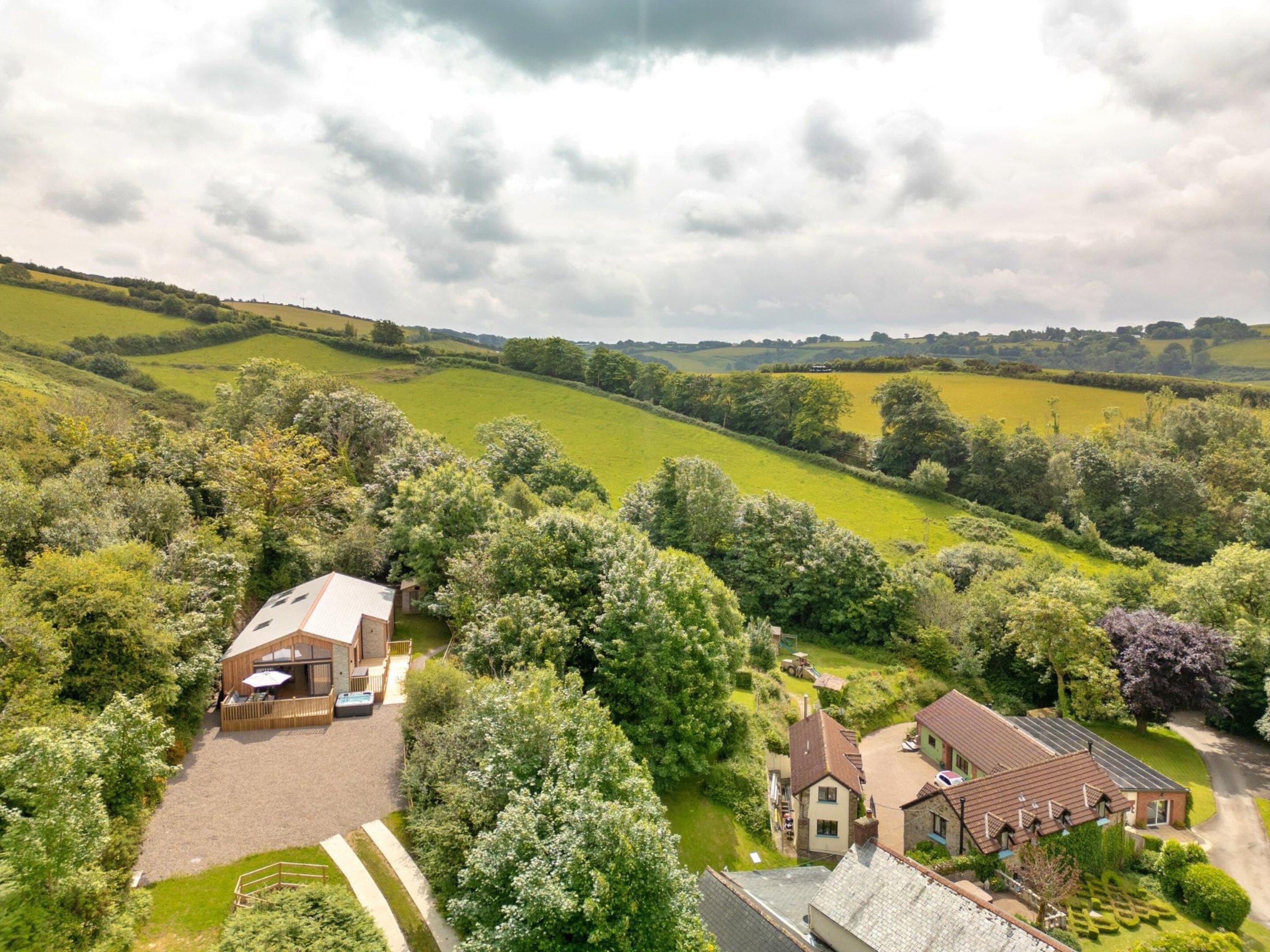 A rural property with a large house, a guesthouse, and a fenced garden area.