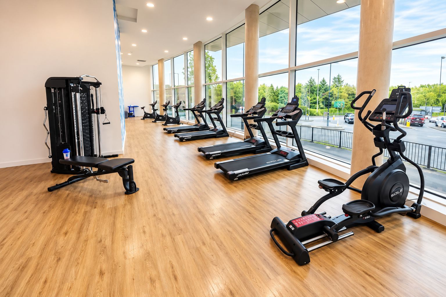 A gym with treadmills, a weight machine, and a bench.