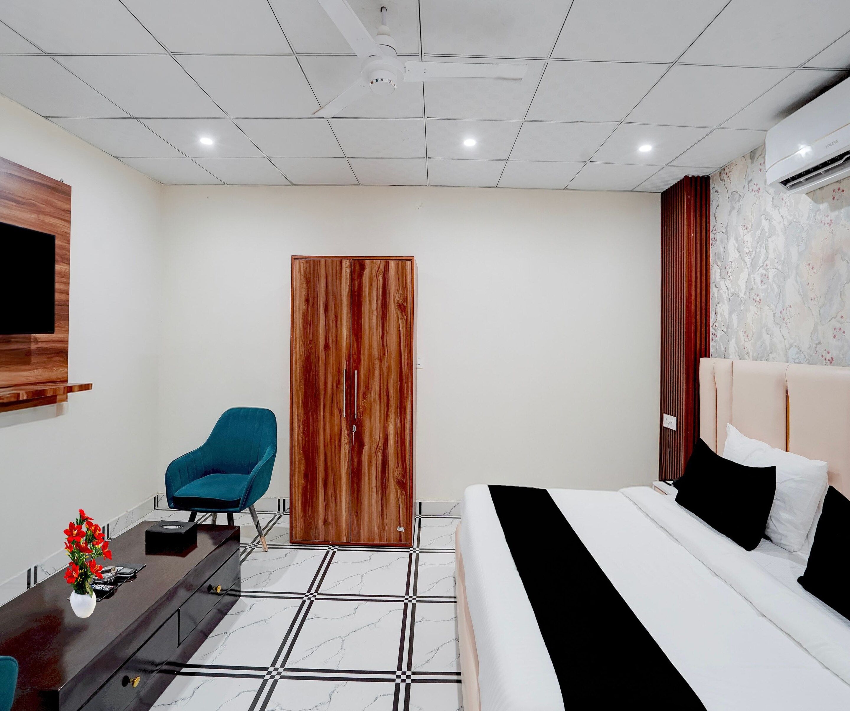 A modern bedroom with a bed, a desk, a chair, and a wardrobe.