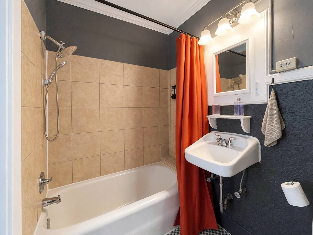 Ein Badezimmer mit einer Badewanne, einer Dusche und einem Waschbecken mit Spiegel darüber.