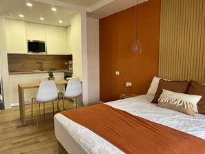 A hotel room with a bed, a desk, and a kitchenette. - Andorra 5 - Studio with pool view (Playa de las Américas)