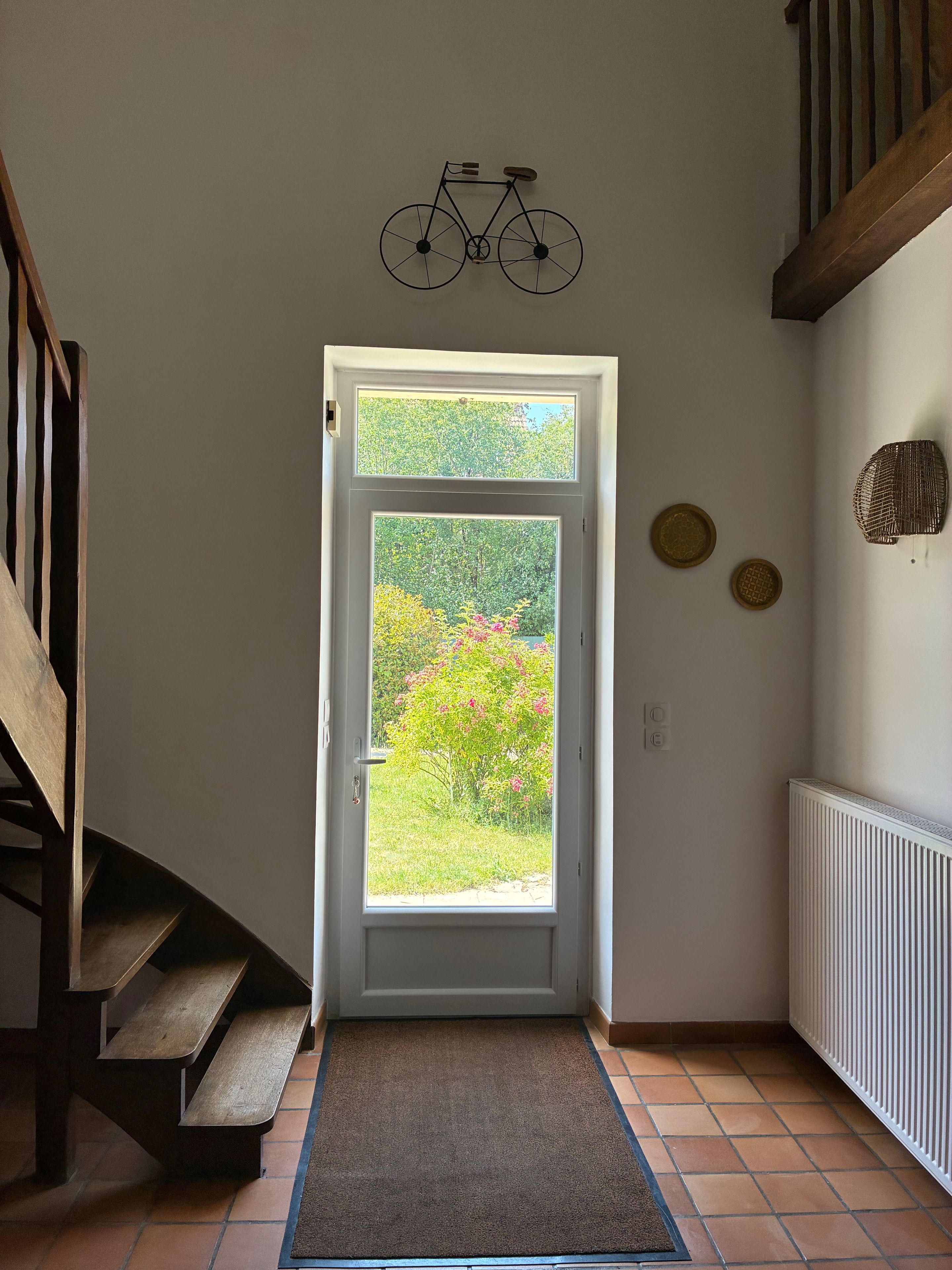 A staircase leading to a door with a view of greenery outside.