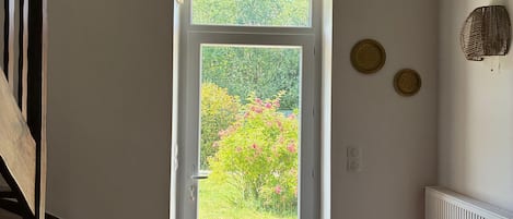 A staircase leading to a door with a view of greenery outside.