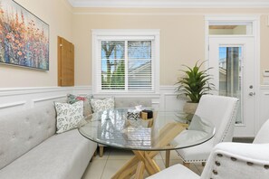 Una sala de estar con una mesa de centro de vidrio, un sofá y una planta en maceta.