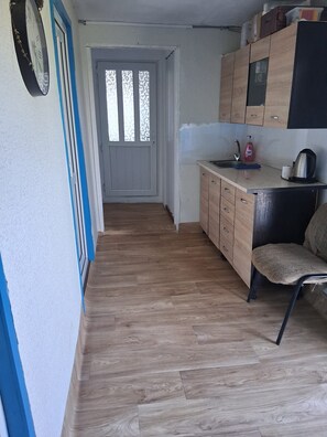 A narrow hallway leading to a door with frosted glass panels.