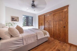 A bedroom with a bed, a window, a ceiling fan, and wooden wardrobe. - Tahoe Park Lodge | Hot Tub & HOA Beach (Tahoe City)