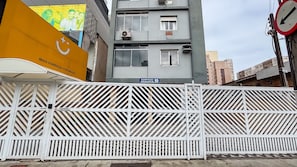 A gated building with a blue sign indicating 'Edifício Gravata 99'. - SHB - Central Shopping 2 min Praia (Santos)