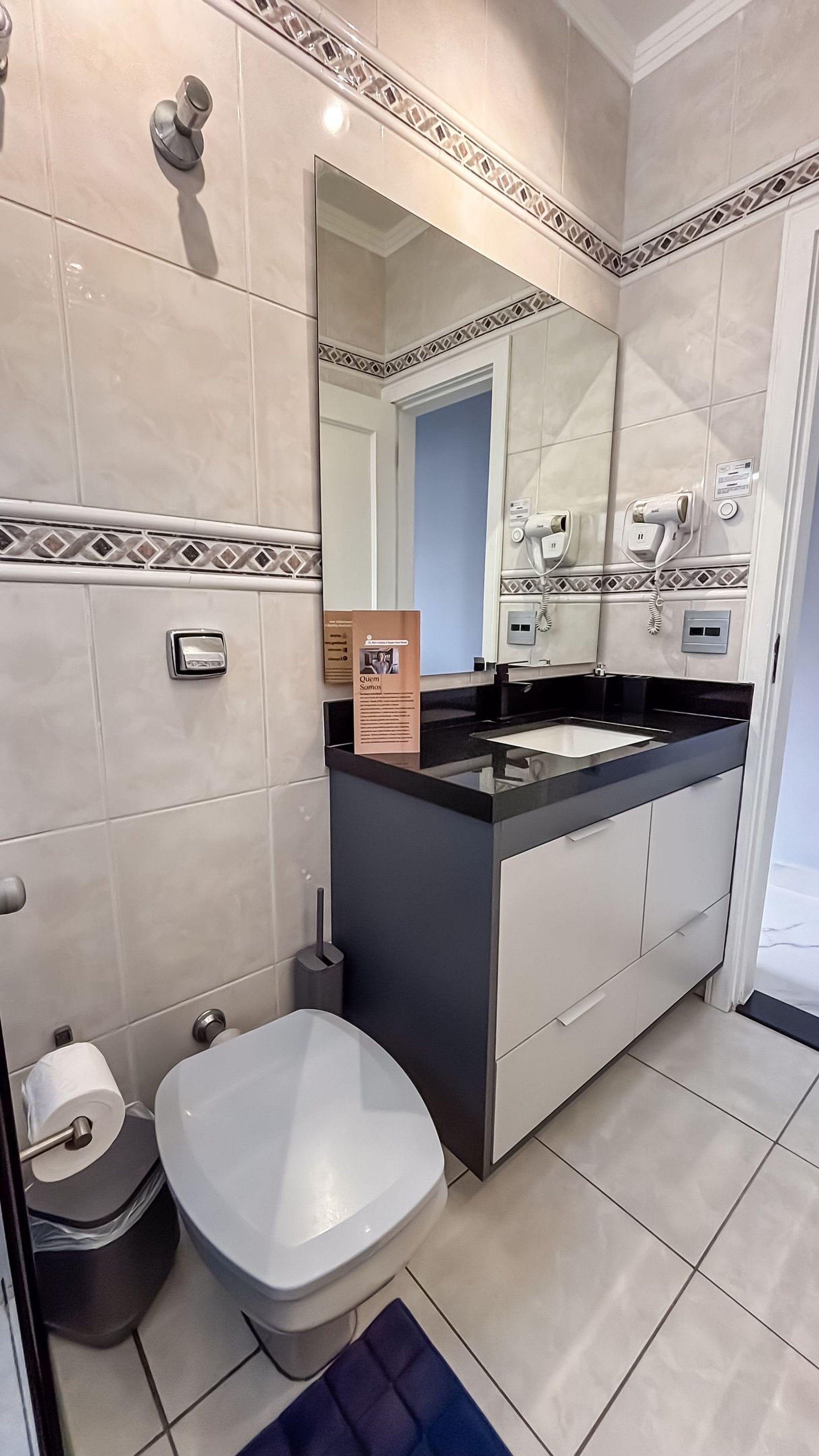 Un baño moderno con inodoro, bidé y lavamanos con espejo.