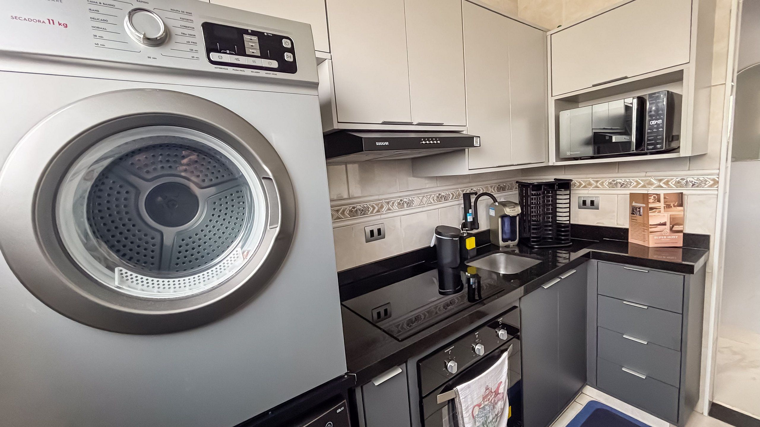 Una cocina compacta con lavadora, microondas y cafetera.