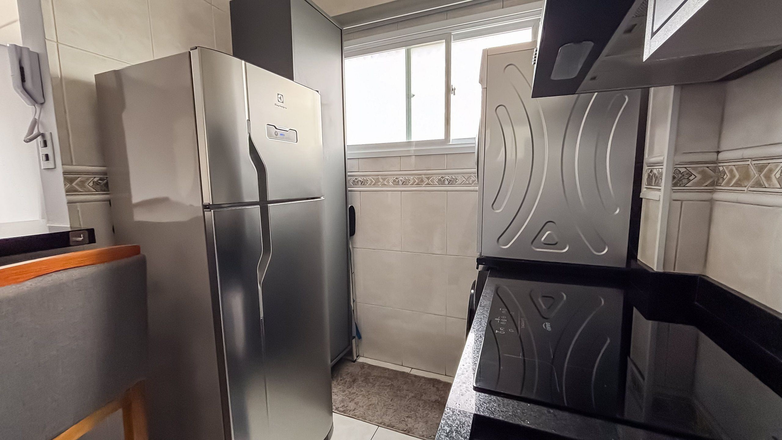 A kitchen with a stainless steel refrigerator, a microwave, and a stove.