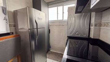A kitchen with a stainless steel refrigerator, a microwave, and a stove.