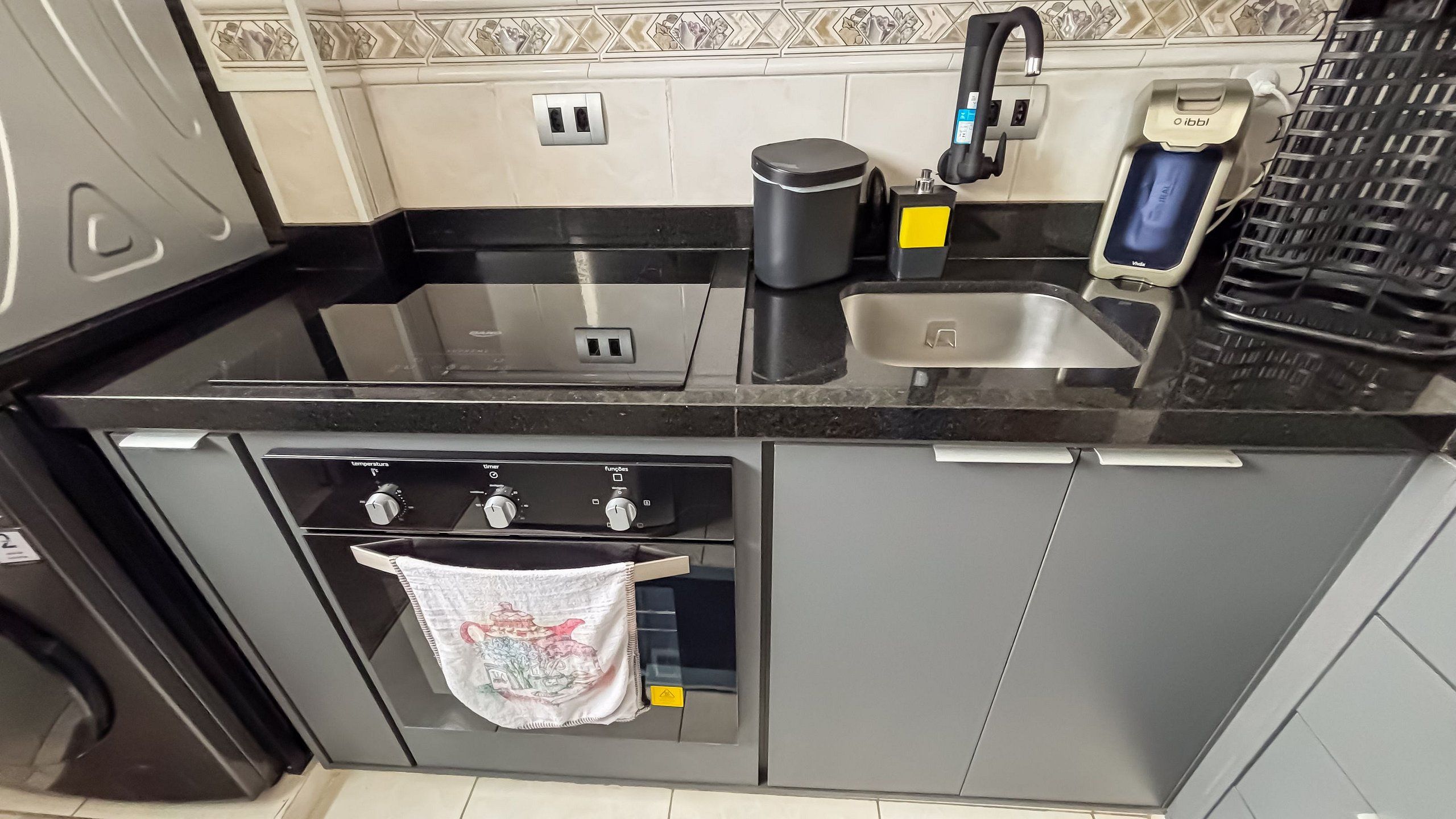 A kitchen with a sink, coffee maker, and oven.
