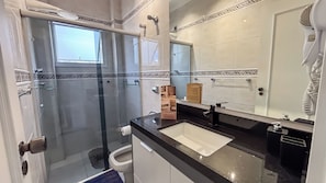 A modern bathroom with a glass shower enclosure, a sink, and a large mirror. - SHB - Central Shopping 2 min Praia (Santos)