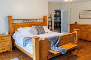 A wooden bed with a headboard, bedside tables, and a bench.