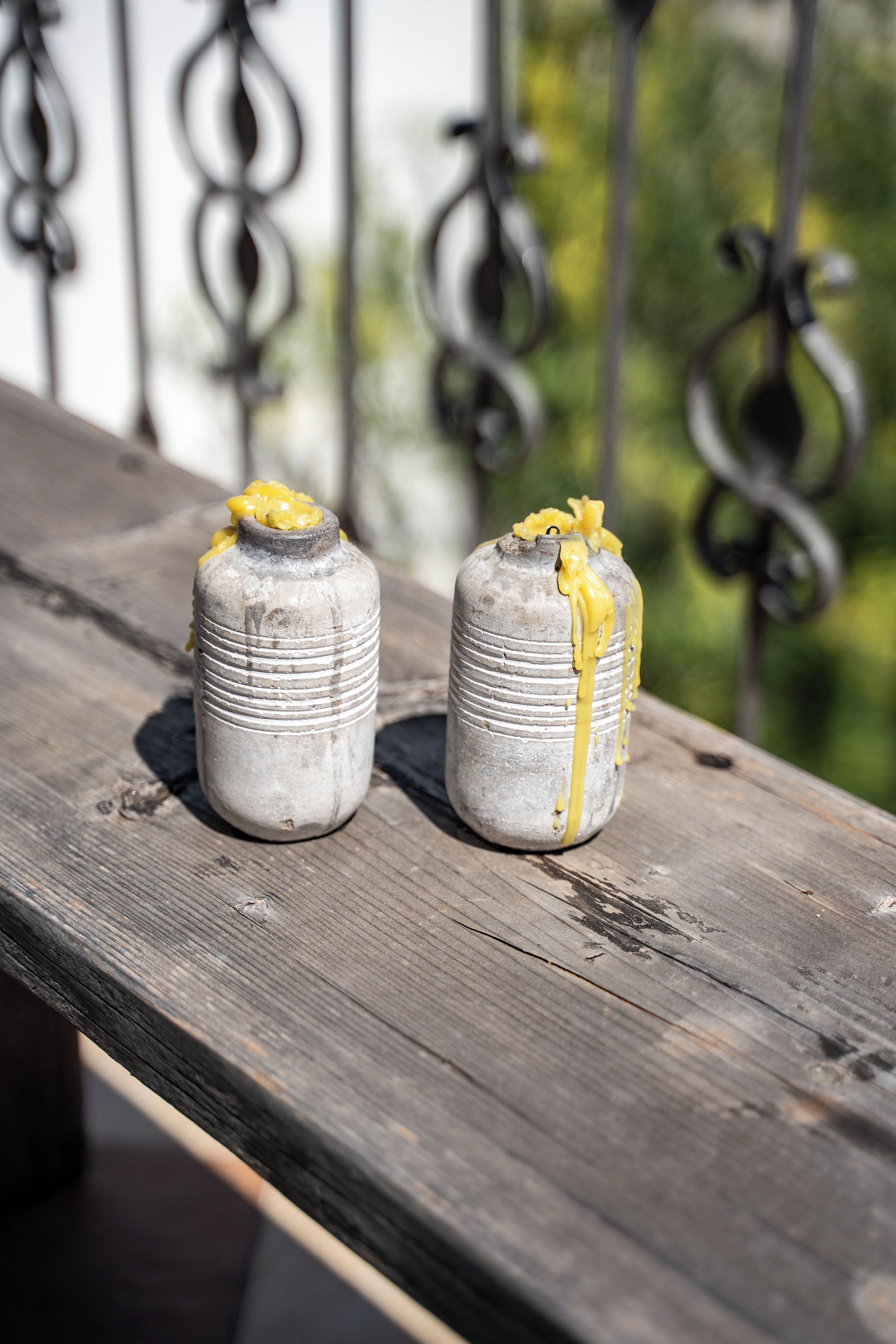 Deux objets cylindriques, surmontés d’un embout jaune, sont posés sur une surface en bois.