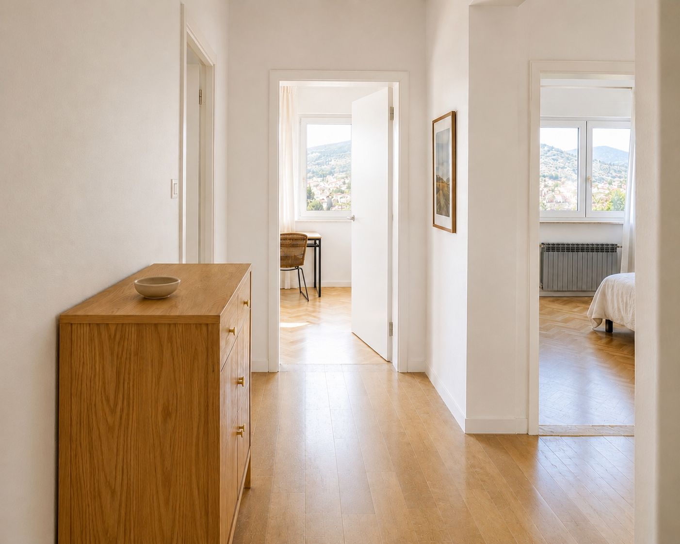 Un corridoio con un armadio in legno, una scrivania con una sedia e un letto con un termosifone.