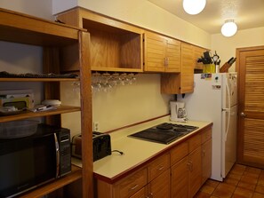 A compact kitchen with wooden cabinets, a microwave, a toaster, a coffee maker, and a refrigerator. - Mt Royal above back deck, Main street and Summit Stage 2 blocks (Frisco)