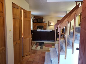 A hallway leading to a living area with a fireplace, a sofa, and a staircase. - Mt Royal above back deck, Main street and Summit Stage 2 blocks (Frisco)