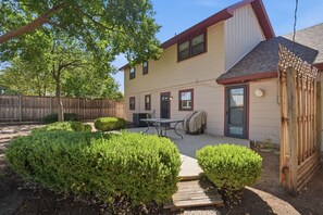 A two-story house with a covered patio, a wooden fence, and well-maintained bushes. - Glenridge Getaway - 3BR/2BA - Centrally Located (Lubbock)