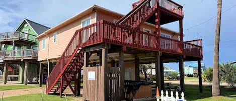 Una casa de dos pisos con una escalera roja que lleva a un balcón.