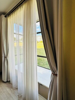 A room with a large window, curtains, and a view of a building and greenery outside. - Modern Fourways -spacious 3bedroom Retreat& 2 Bath (Johannesburg)