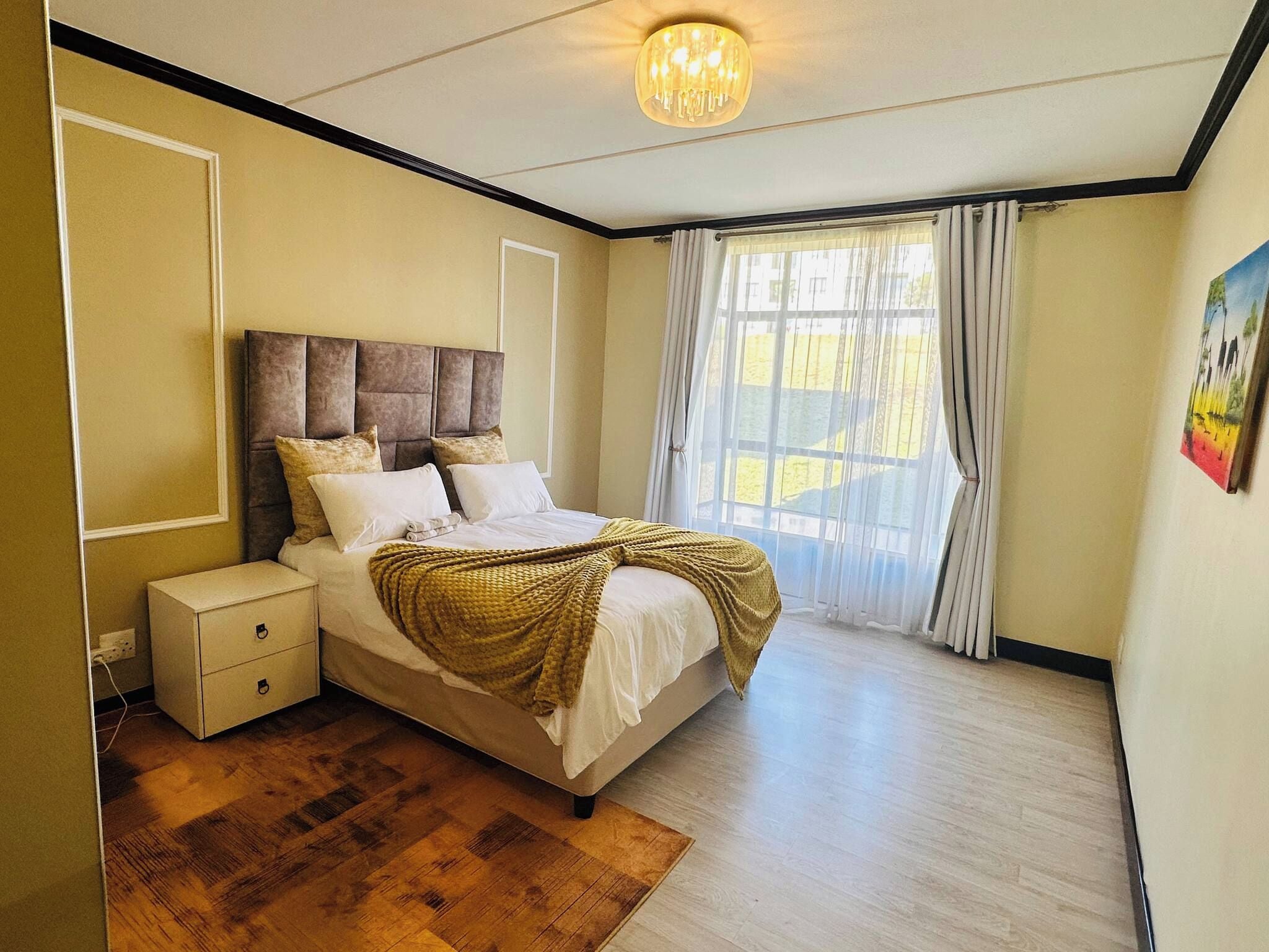 Ein Schlafzimmer mit Bett, Nachttisch und einem Fenster mit Vorhängen.