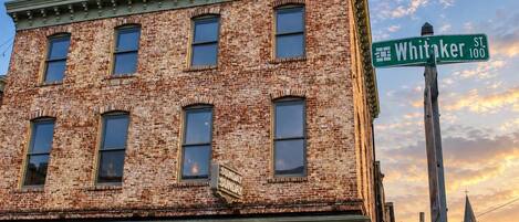A brick building with a green street sign for Whitaker St.