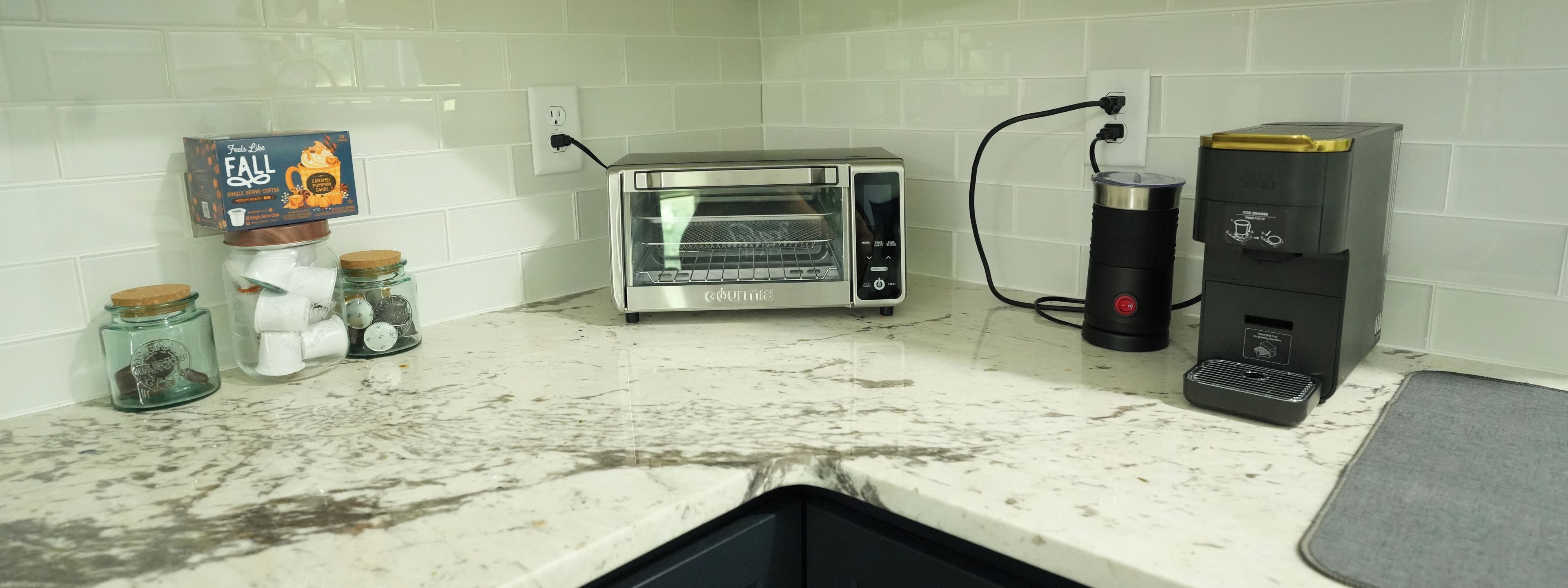 A kitchen with a toaster oven, a coffee maker, and a food steamer.